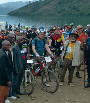 Représentation de l'article Autour du Lac Kivu, des cyclistes entourrés de locaux.